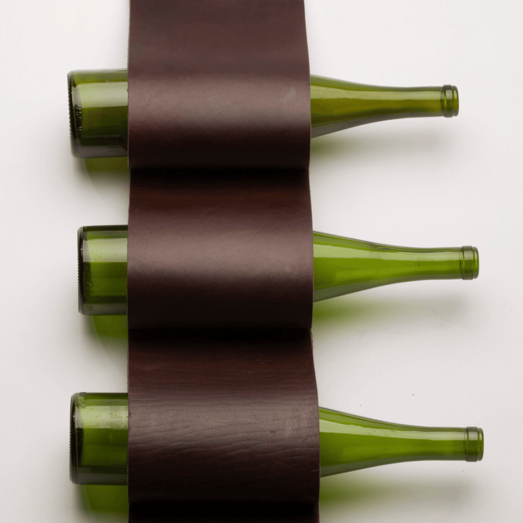 Arte de la pared de cuero se duplica como un soporte de vino colgante de 4 botellas, pero también se puede utilizar para el correo, revistas y toallas. Cortado a mano en cuero de primera calidad y cosido a mano.