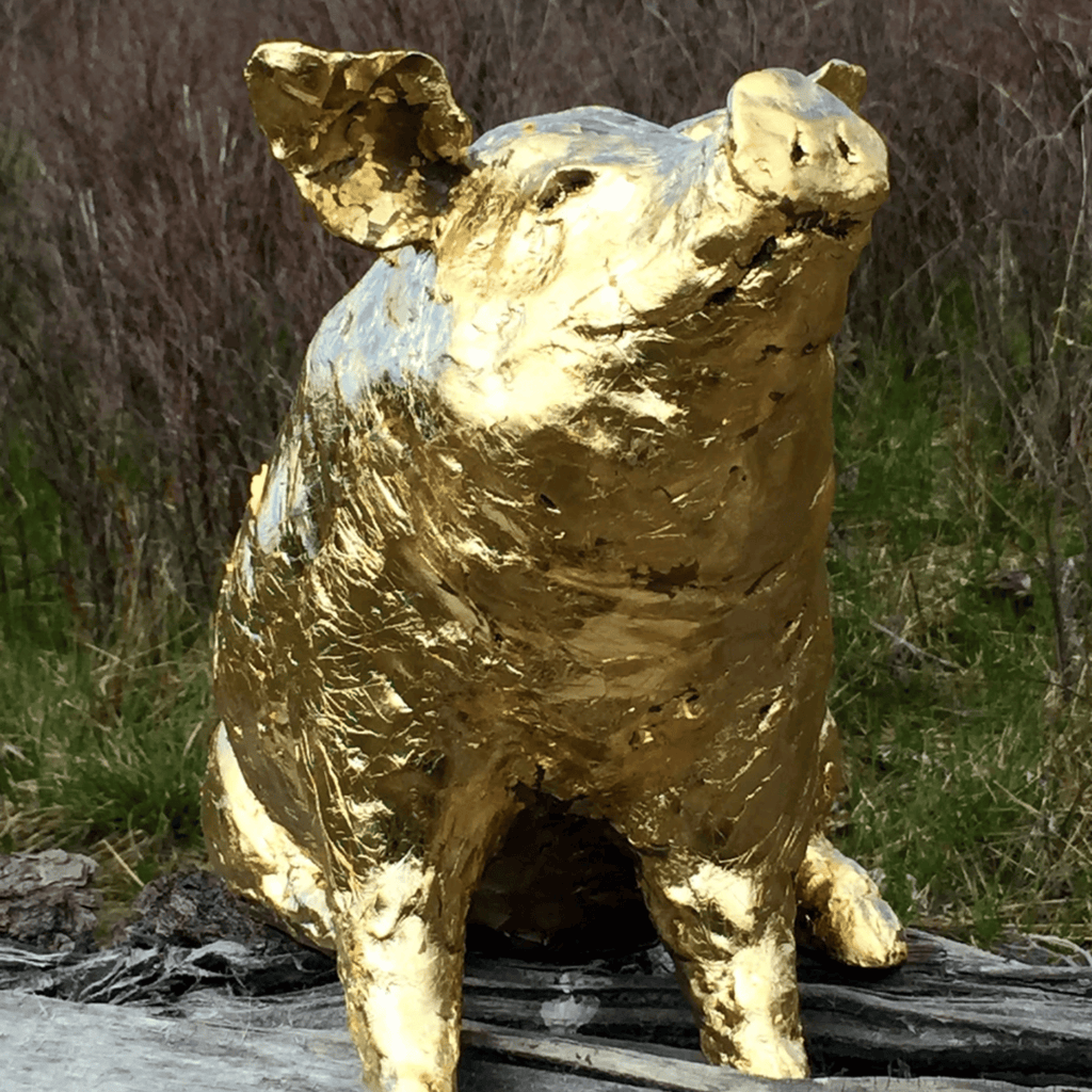 Escultura de cerdo dorada